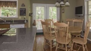 A kitchen with a granite countertop, wooden chairs, and a dining table. - Rumbling Bald Resort/Lake Lure/ Small Fee for Golf Cart.  Low cleaning fees. (Lake Lure)