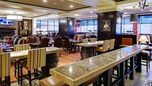 A restaurant with multiple tables and chairs, a fireplace, and large windows. - Penthouse Ski-In Ski-Out Above Sheraton 1bd 1.5ba (Steamboat Springs)