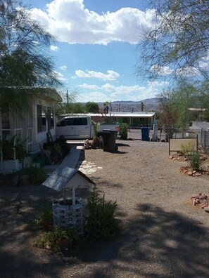 A campground with RVs, a covered picnic area, and a view of distant mountains.
