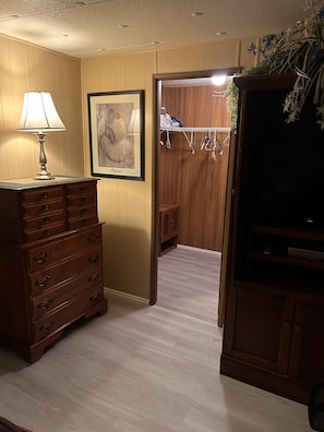 Comfortable room with a dresser, wardrobe, and TV.