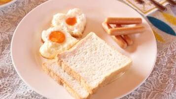 A plate with two slices of white bread, two fried eggs, and a few pieces of toast.