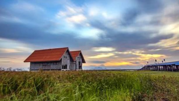 A rustic wooden barn with a red roof in a field. - Rimlay Park Resort (Phatthalung)