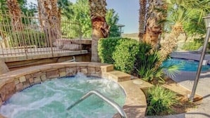 A hot tub surrounded by palm trees and a pool. - Extra large one bedroom with access to the Las palmas Resort  pools. (Saint George)