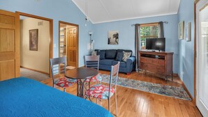 Una habitación con cama, sofá, televisión, cómoda y silla.