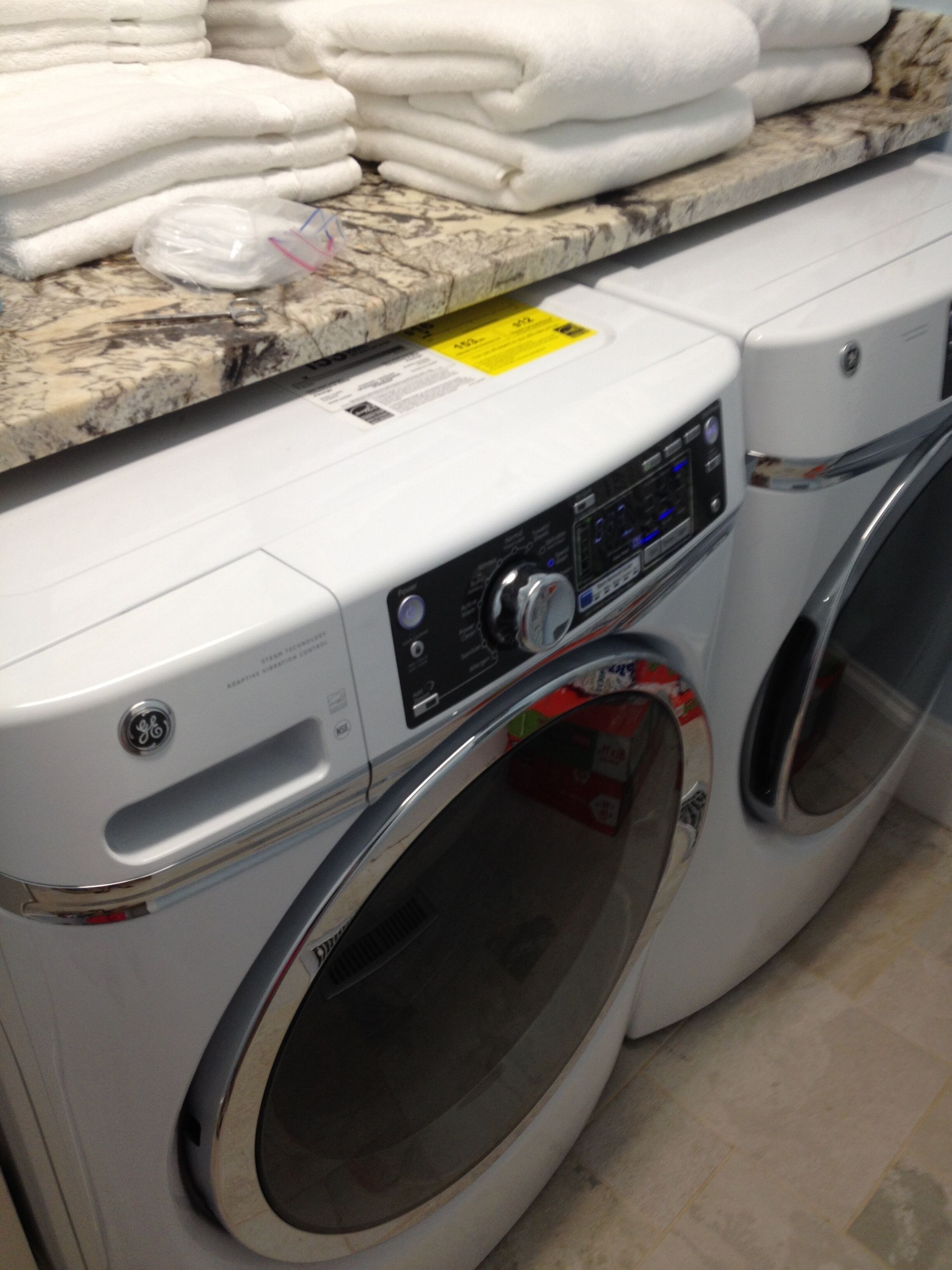 A front-loading washing machine with a control panel and a stainless steel door.