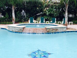 Una piscina con borde de piedra y fuente de agua.