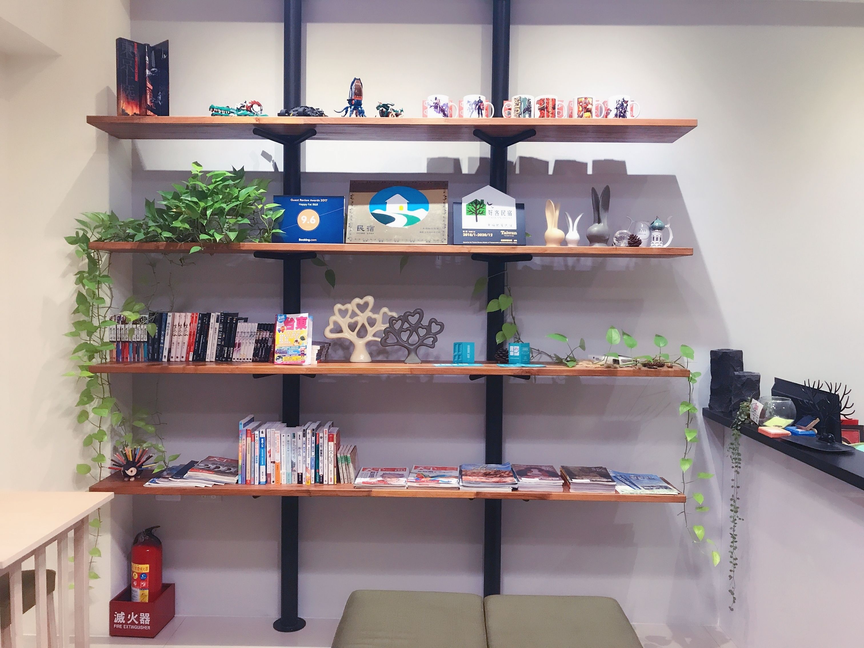 A multi-tiered bookshelf with various books, decorative items, and a fire extinguisher.