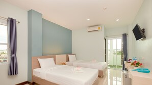 A hotel room with two beds, a desk, a TV, and an air conditioning unit. - Je t'aime Hotel (Trang)