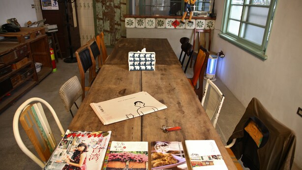 A wooden dining table with magazines, a tissue box, and a keychain. - Adore Tainan - Adore Space (Tainan)