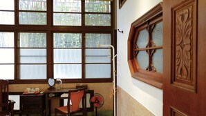 A room with large windows, a desk with a chair, a fan, and a wooden door. - Adore Tainan - Adore Space (Tainan)