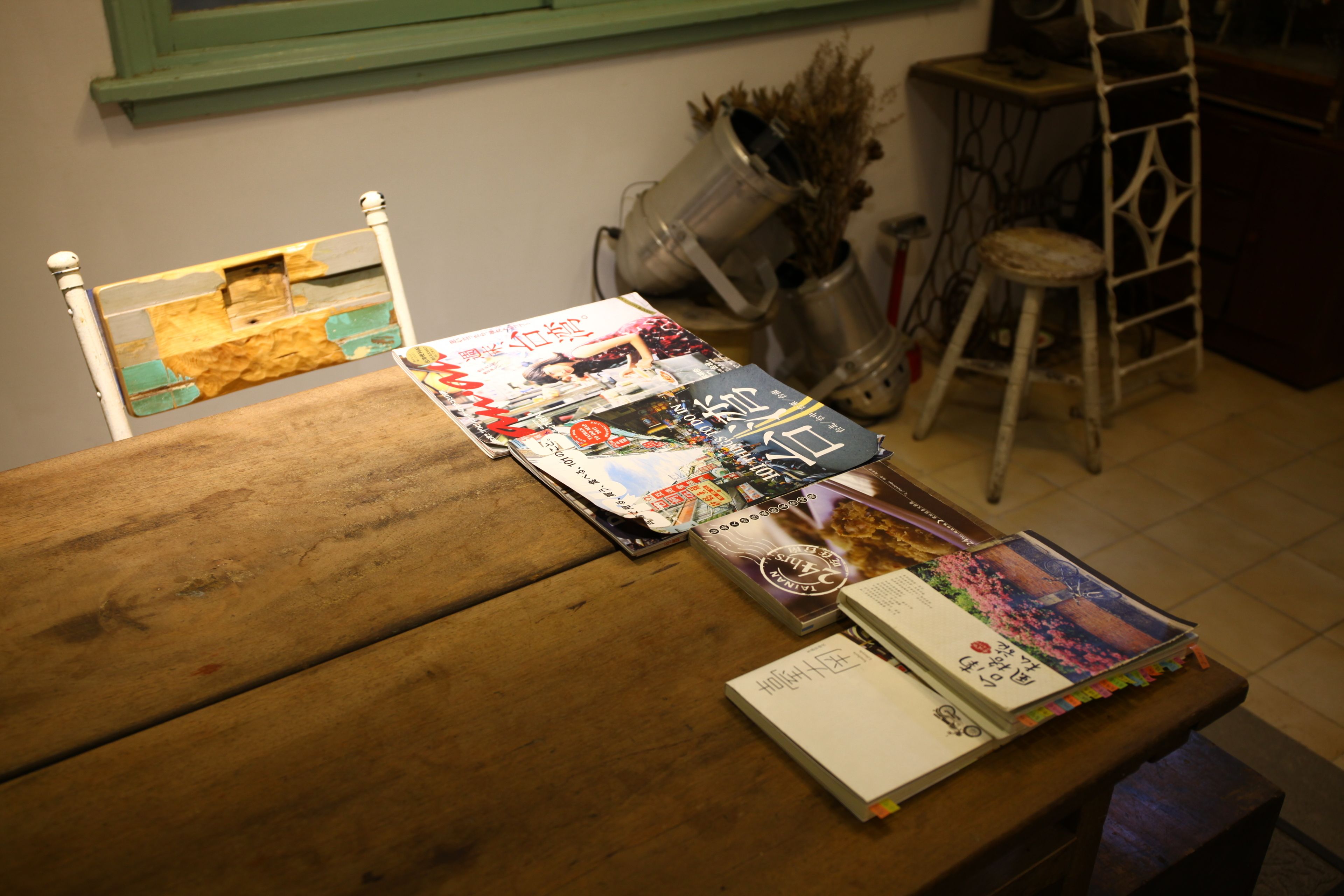 A wooden table with magazines and a book.