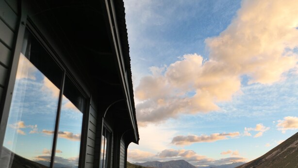 A wooden deck with a railing overlooking a mountainous landscape. - Porters Lodge (Castle Hill)