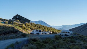 A remote cabin with a gravel driveway, surrounded by hills and mountains. - Porters Lodge (Castle Hill)