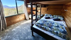 A bunk bed room with a view of a mountainous landscape. - Porters Lodge (Castle Hill)