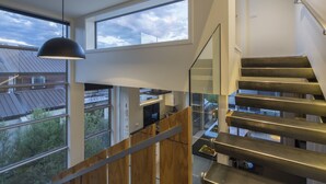 A modern interior with a staircase, large windows, and a pendant light. - 15 Melbourne by Staysouth (Queenstown)