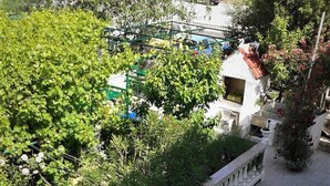 A terrace with white lounge chairs, a stone balustrade, and lush greenery. - Air-conditioned cozy, quiet, beautiful and loving apartment on the island of Rab (Palit,Rab)