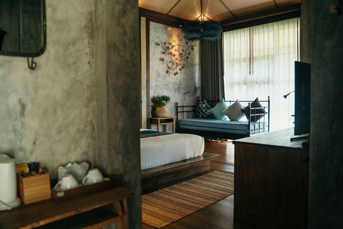 A modern bedroom with a bed, bedside table, and a decorative wall piece.
