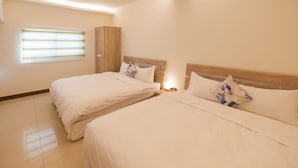 Habitación de hotel con dos camas, un armario y una ventana con persianas.