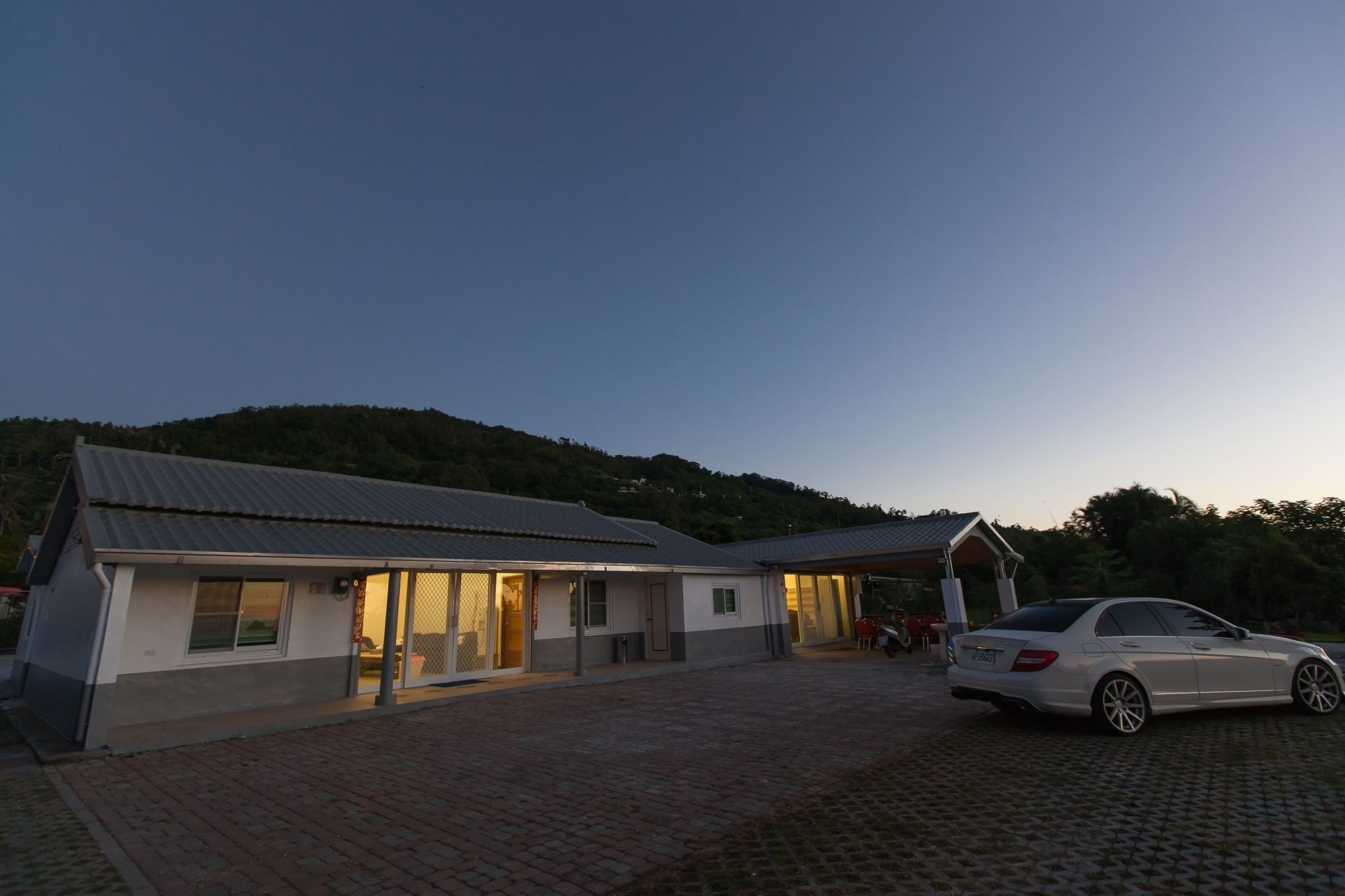 A modern house with a car parked in front.