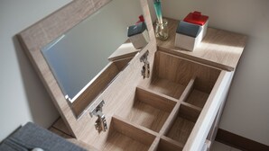 Un tocador de madera con espejo, varios compartimentos y un portalápices.