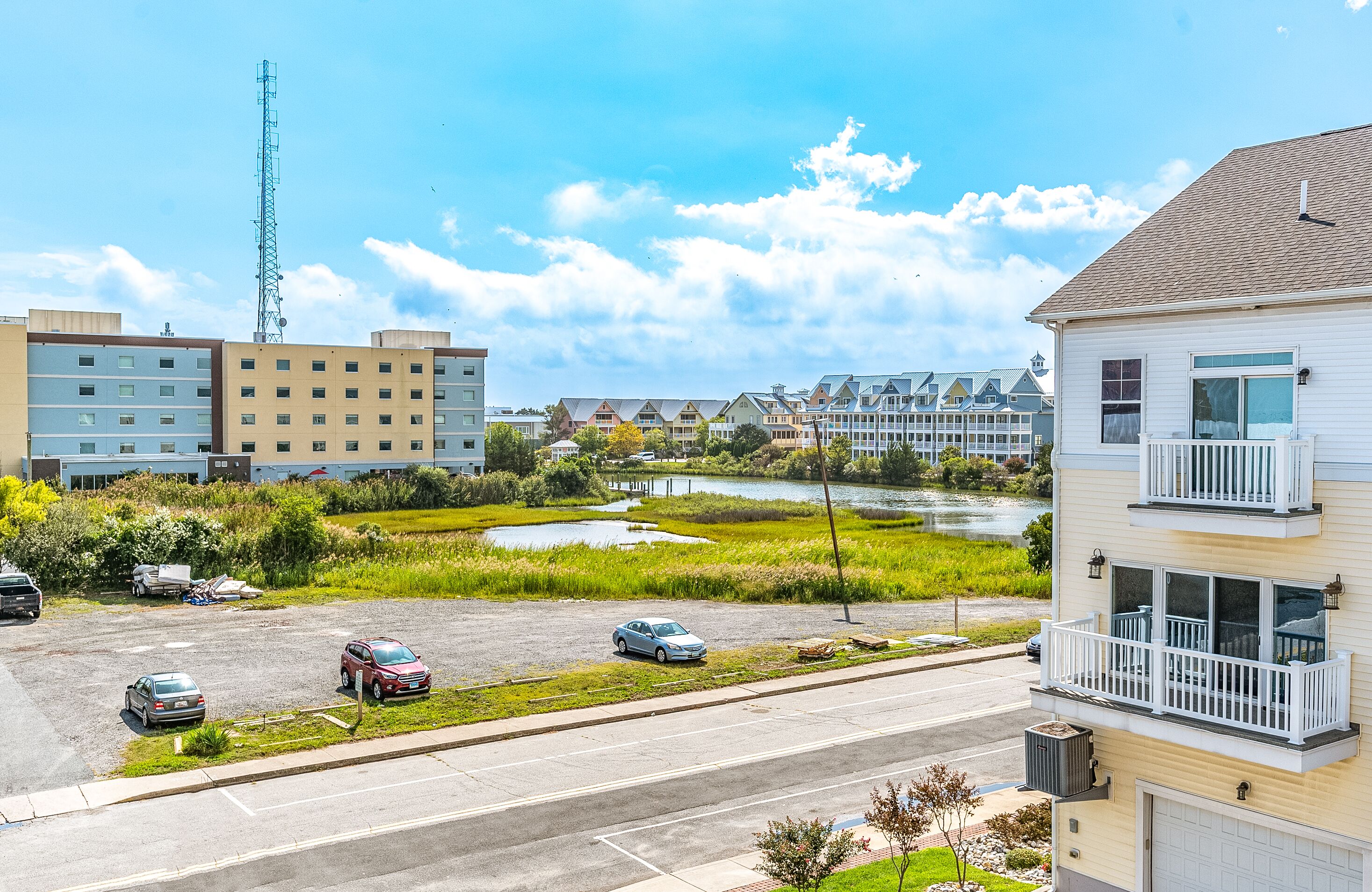 A residential area with a parking lot, a river, and buildings with balconies.
