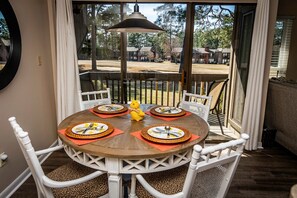 A dining table set for four with a view of a backyard. - Cozy 1 bedroom condo in walking distance to the Club, the Cradle & the Village! (Pinehurst)