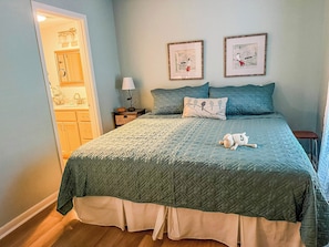 A bedroom with a bed, a nightstand, a lamp, and two wall-mounted pictures. -  Cozy 1 bedroom condo in walking distance to the Club, the Cradle & the Village! (Pinehurst)