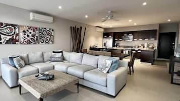 A modern living room with a grey sectional sofa, a coffee table, and abstract wall art.