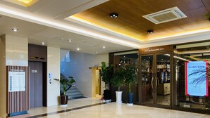 Un vestíbulo moderno y limpio, con piso pulido, una escalera y un restaurante llamado BONAPPETIT.