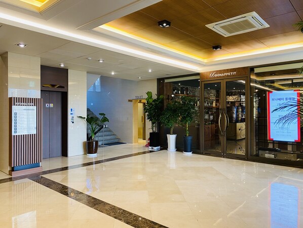 A clean, modern lobby with a polished floor, a staircase, and a restaurant named BONAPPETIT. - New Donghae Hotel (Donghae)