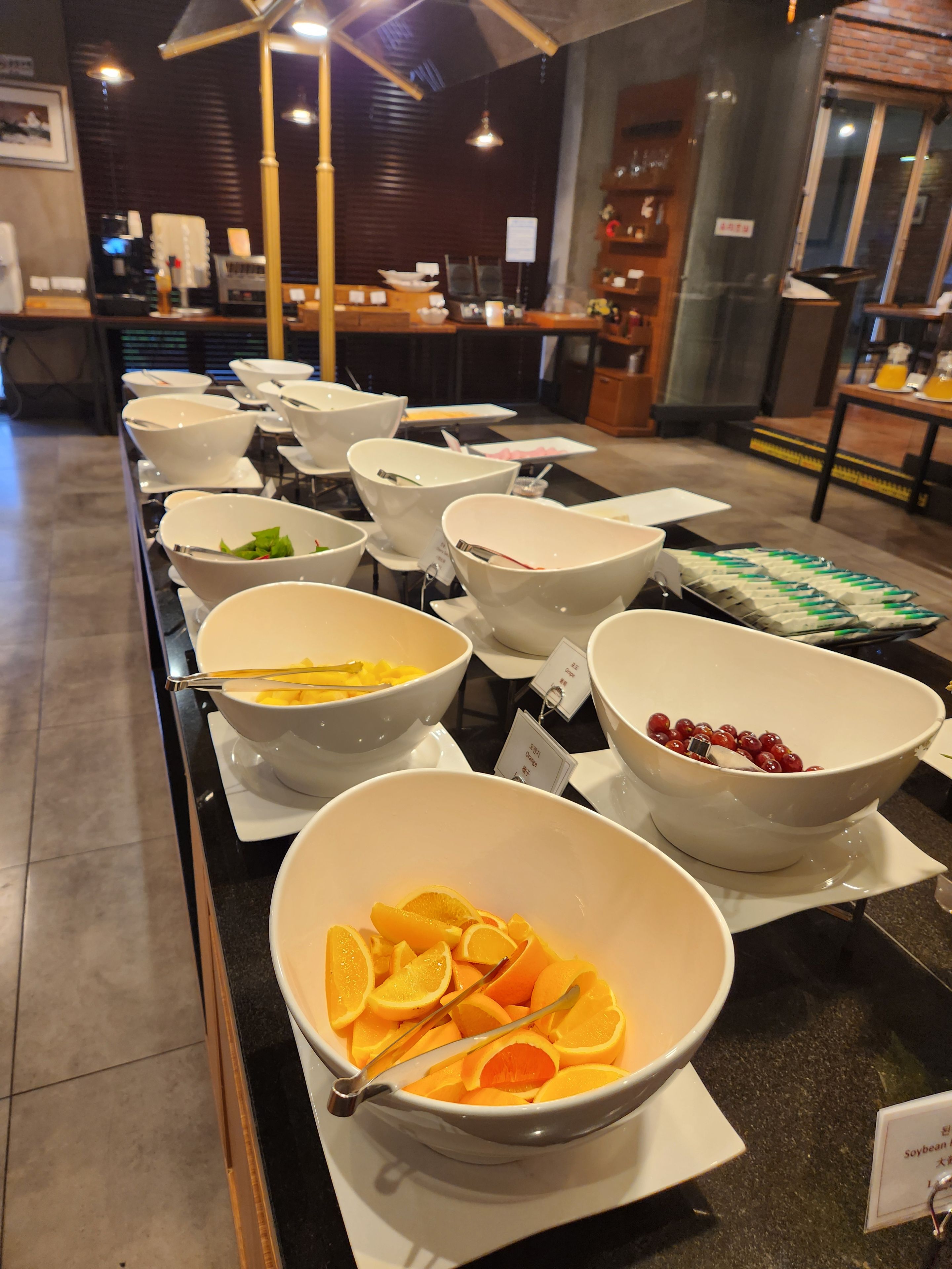 A buffet setup with various bowls containing fruits and vegetables.