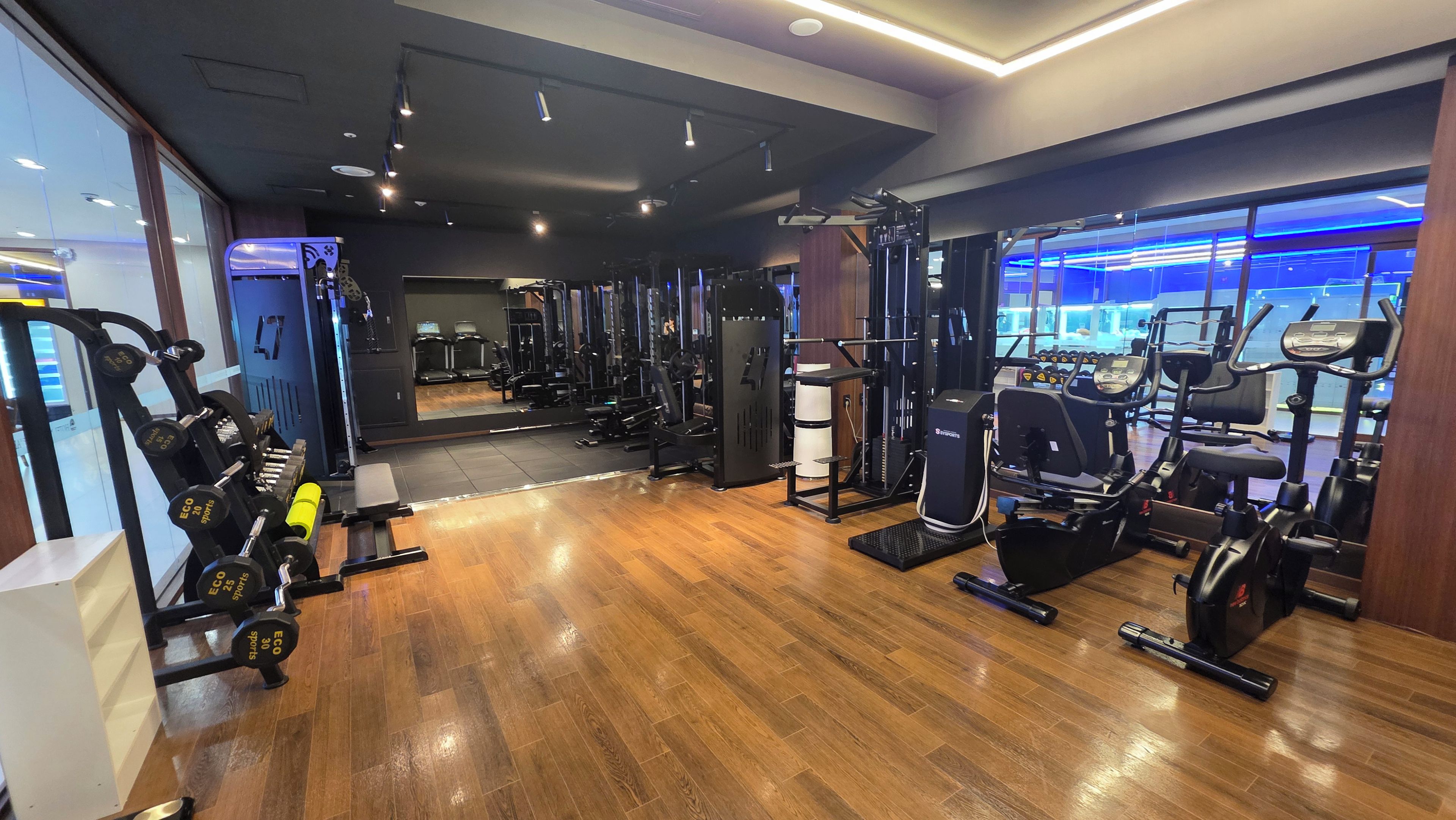 Et fitnesscenter med forskellig træningsudstyr, herunder løbebånd og styrkemaskiner.
