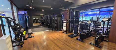 Et fitnesscenter med forskellig træningsudstyr, herunder løbebånd og styrkemaskiner.