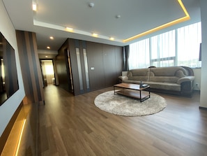 Suíte real, 4 quartos | Sala de estar | TV de tela plana 50 polegadas com canais via satélite, TV