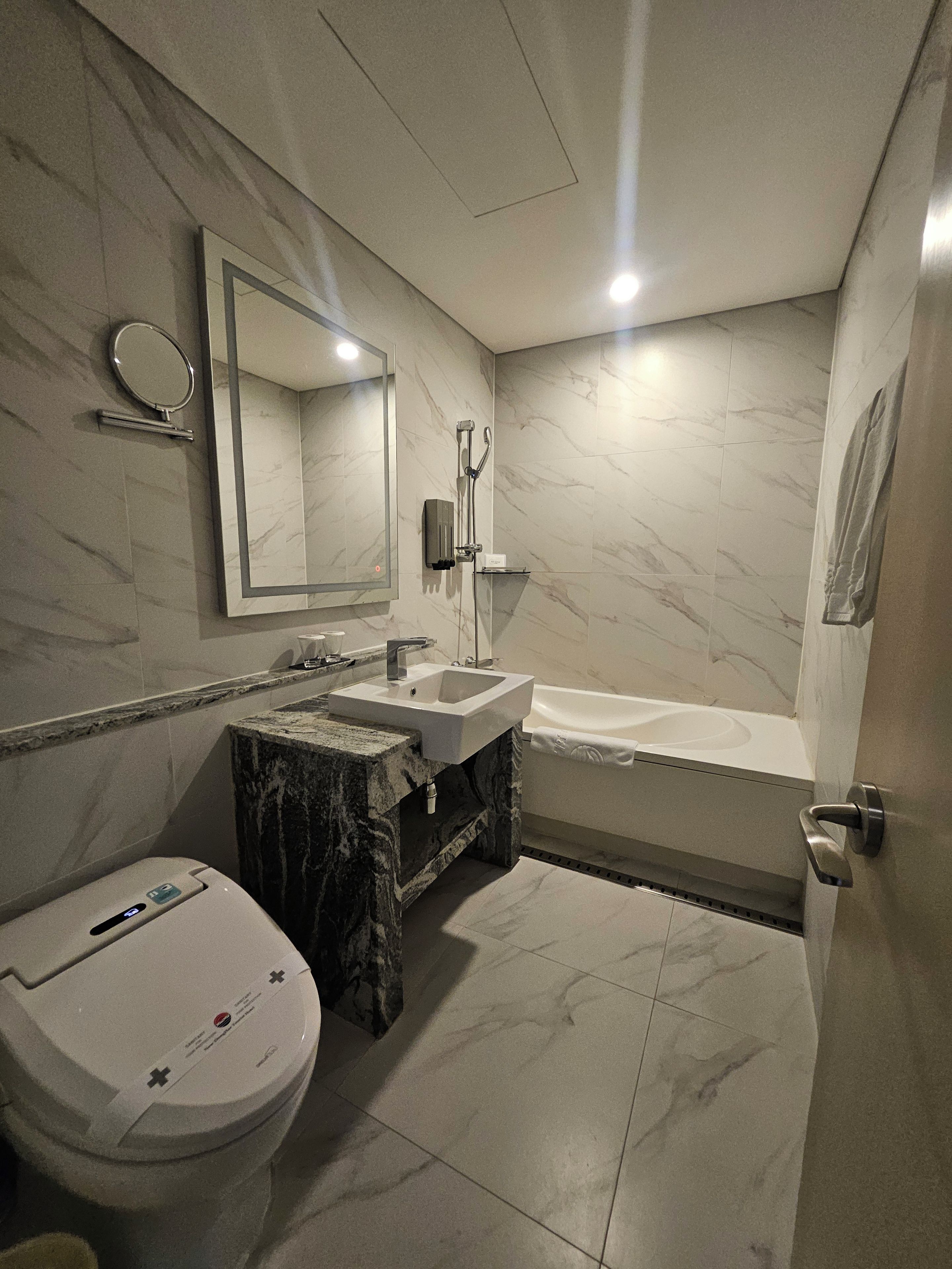 A modern bathroom with a toilet, sink, and bathtub.