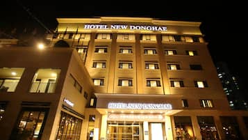 A multi-story hotel with illuminated signage reading 'HOTEL NEW DONGHAE'.