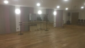 A dance studio with wooden floors, mirrors, ballet barres, and ceiling lights. - Olympic Regina Hotel (Giustino)