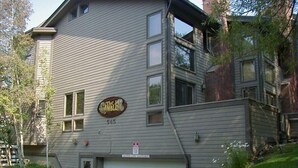 A multi-story building with a garage door, a sign reading "The Caballer," and a small sign indicating "No Parking."
