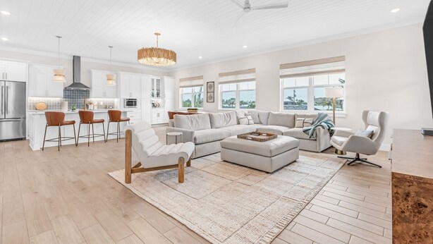 A spacious living area with a large sectional sofa, a coffee table, and a dining area with bar stools.