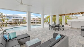 An outdoor patio with a pool, seating area, and a view of the surrounding neighborhood.