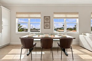 Une cuisine moderne avec un coin repas, de grandes fenêtres et une vue sur le quartier.