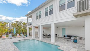 A pool area with lounge chairs and a dining table.