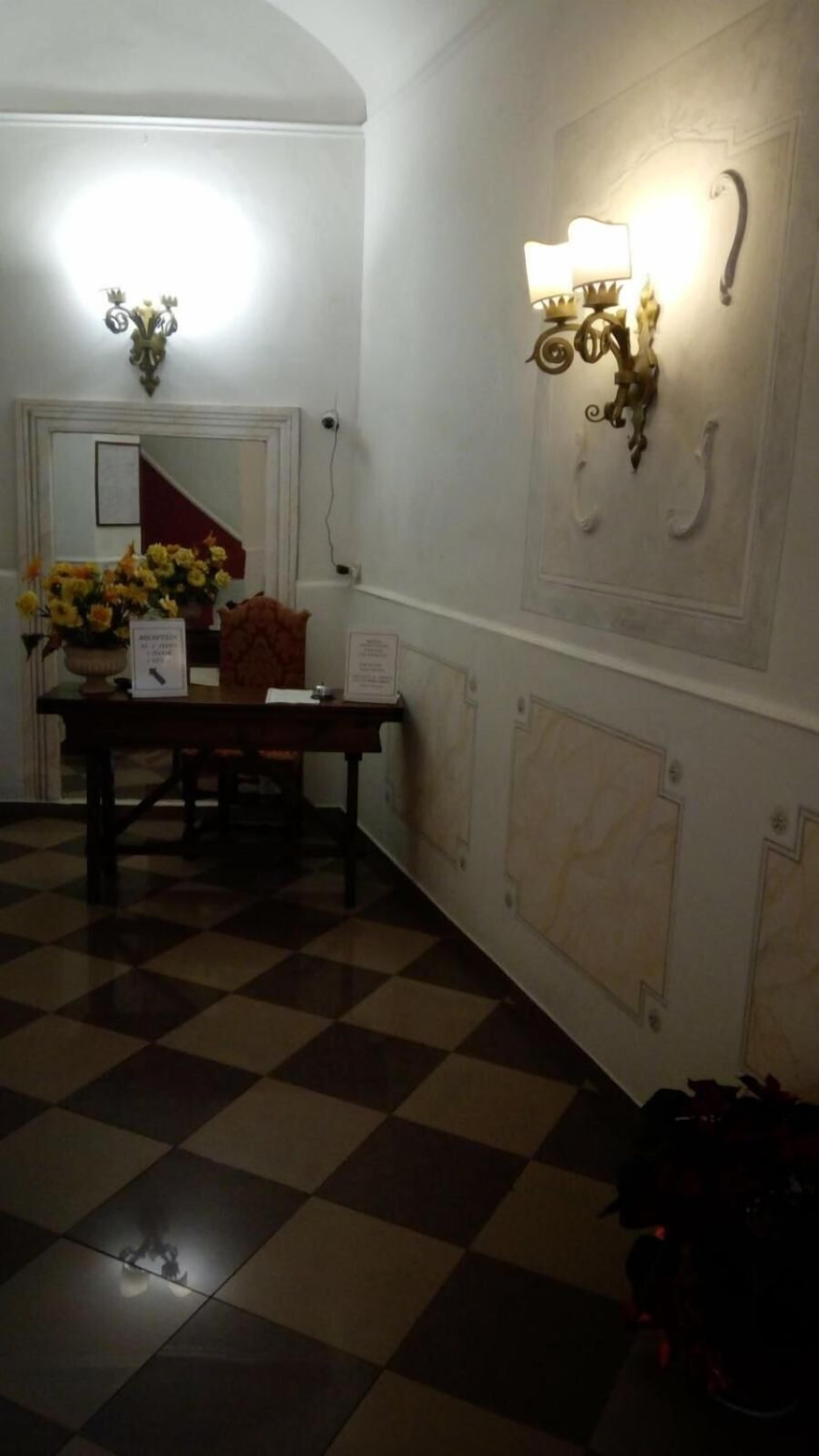 Un terra de quadrícula, una taula amb un ram de flors i aplics de paret.
