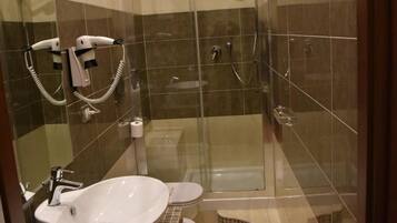 A modern bathroom with a large sink, toilet, and glass-enclosed shower.