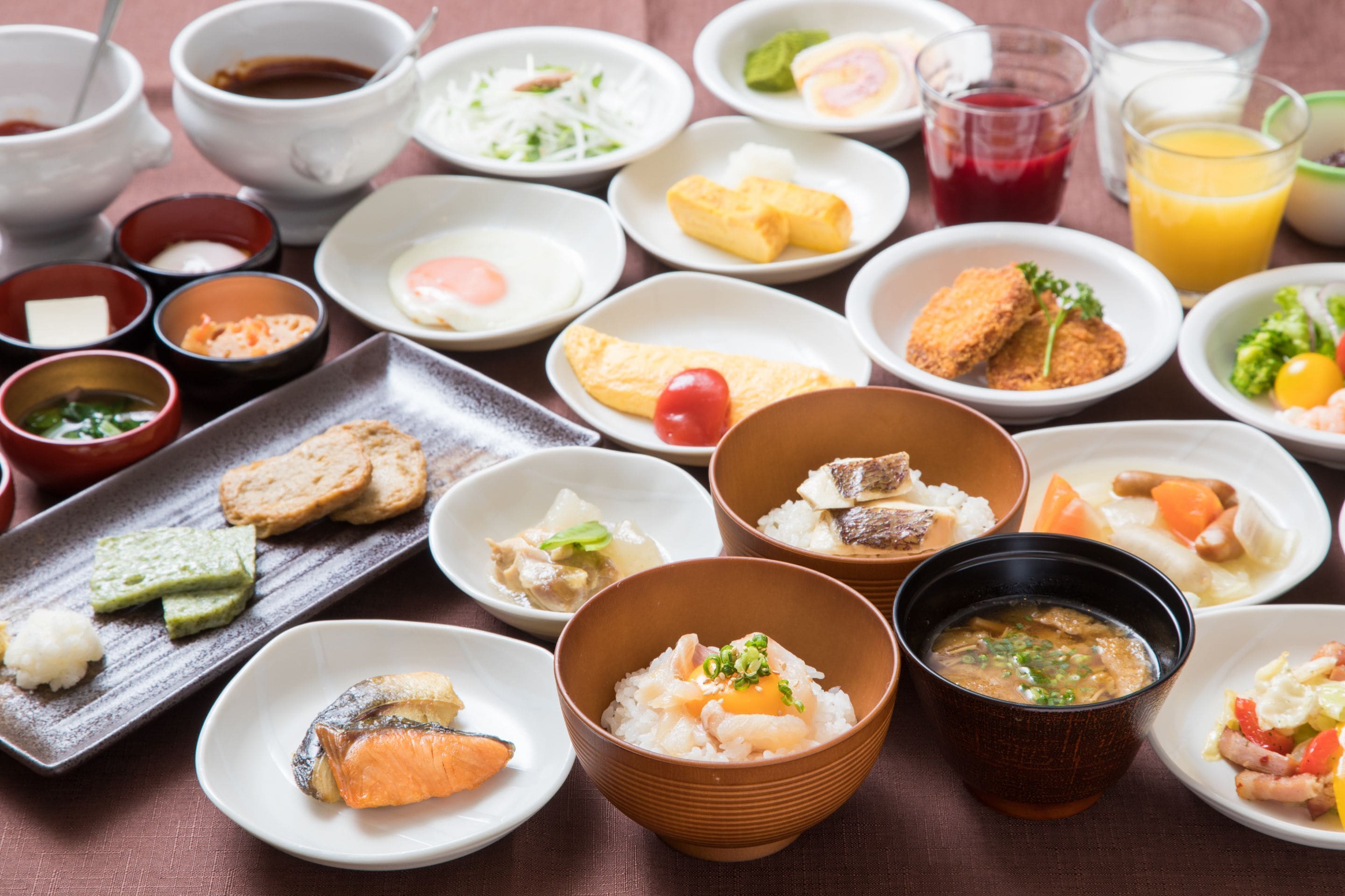 A variety of dishes including sushi, rice bowls, and soup, arranged on a table.