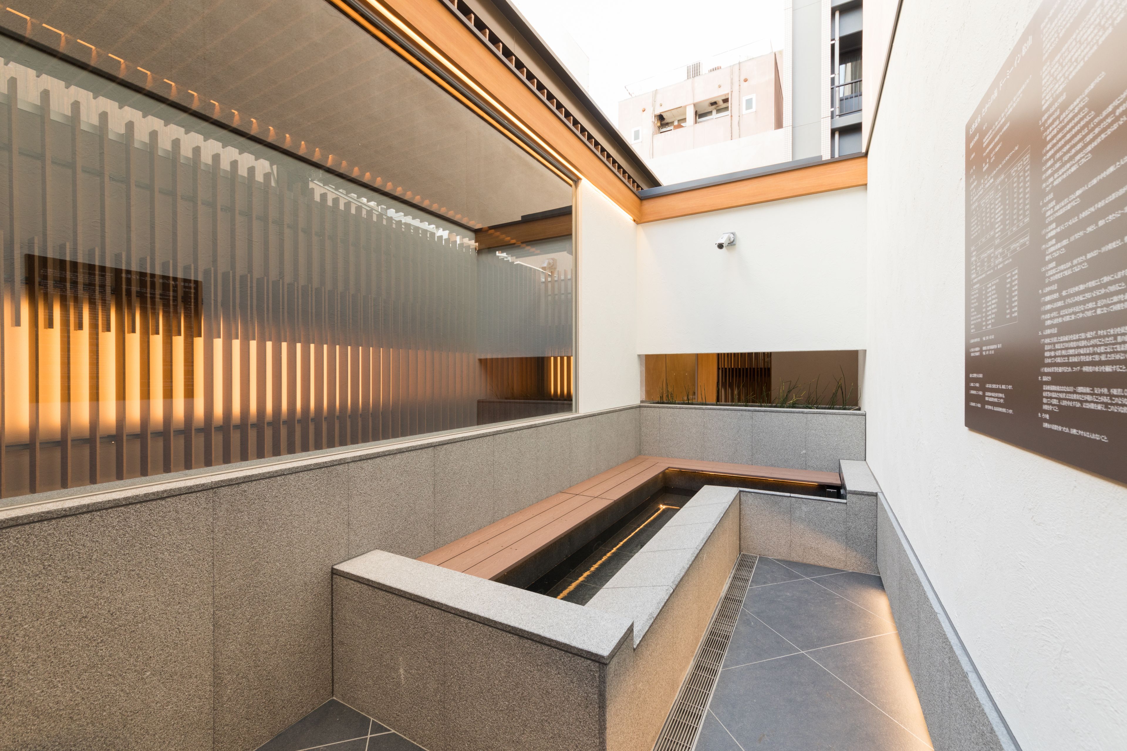 Ein modernes Interieur mit einer Sitzecke, einer Wandtafel mit Informationen und Blick ins Freie.