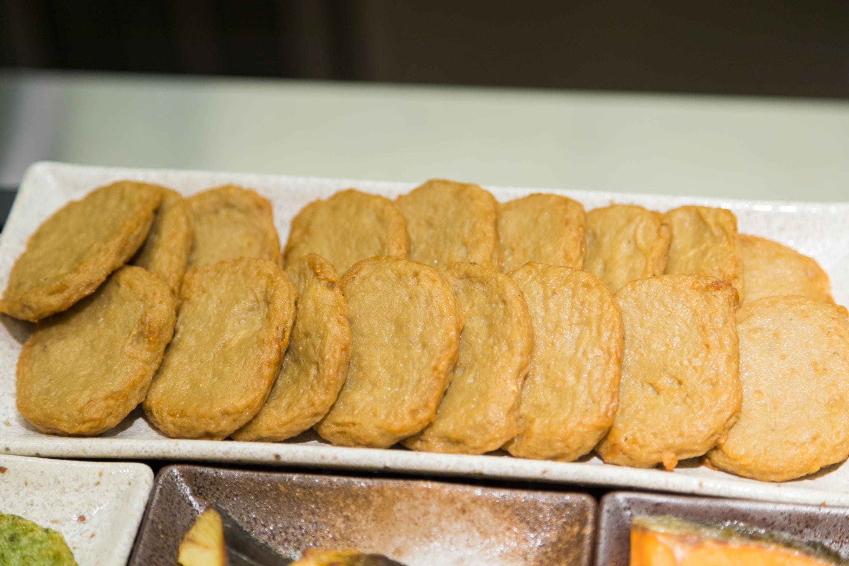 A tray of golden-brown pastries arranged neatly on a white plate.