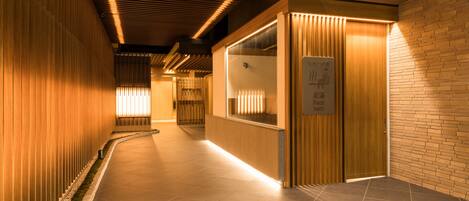 A corridor with wooden paneling, a reception desk, and a sign indicating a foot bath.
