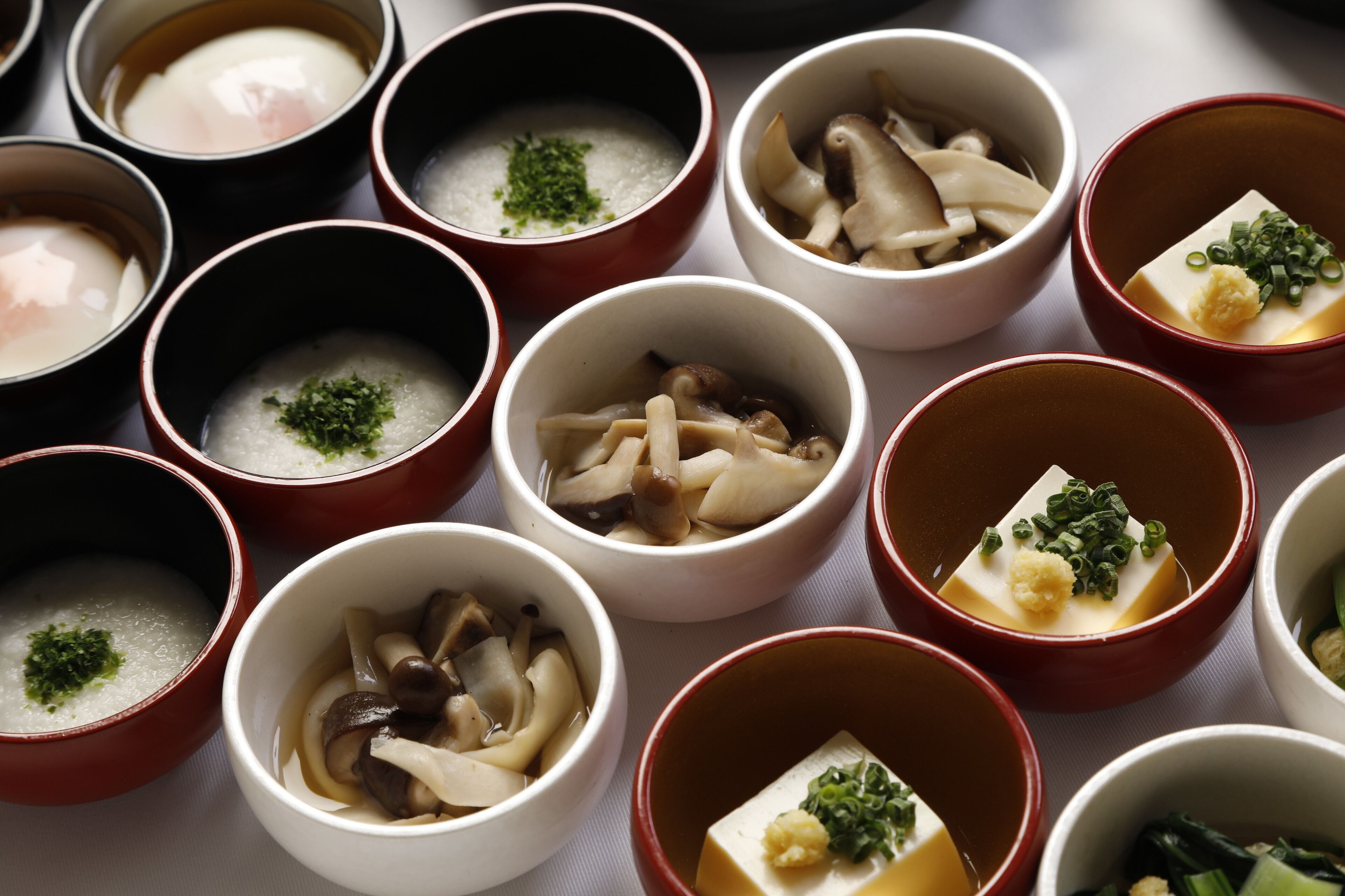 A variety of bowls containing different types of food, likely a selection of Japanese dishes.