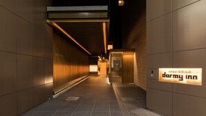 Un couloir avec une enseigne indiquant « Darmy Inn », ce qui signifie qu’il s’agit d’un hôtel. Le couloir présente un design moderne, avec un revêtement de sol carrelé et des éléments décoratifs en bois.